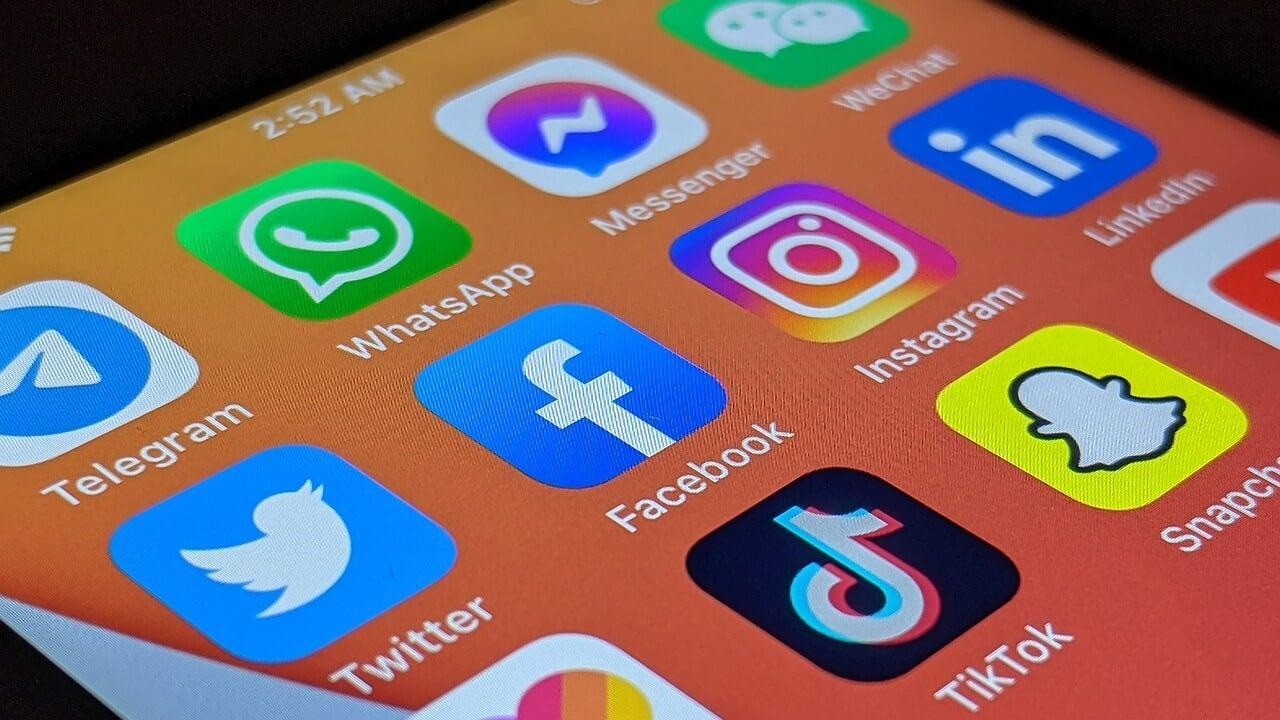Smartphone screen with social media app icons like Instagram, Facebook, WhatsApp, and LinkedIn